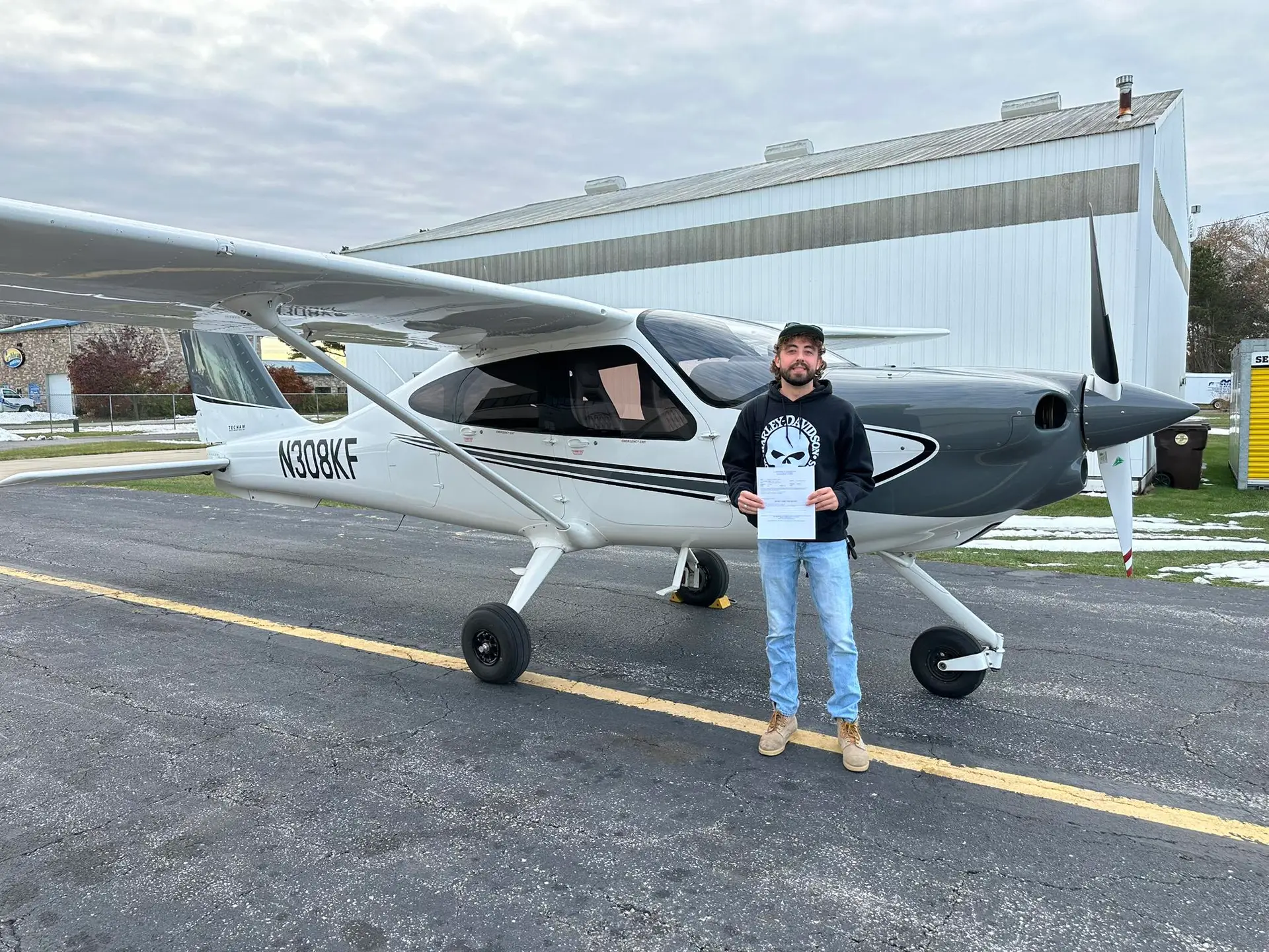 Student holding a TECNAM P2010 certificate at Eagle Aircraft Flight Academy in Valparaiso, IN
