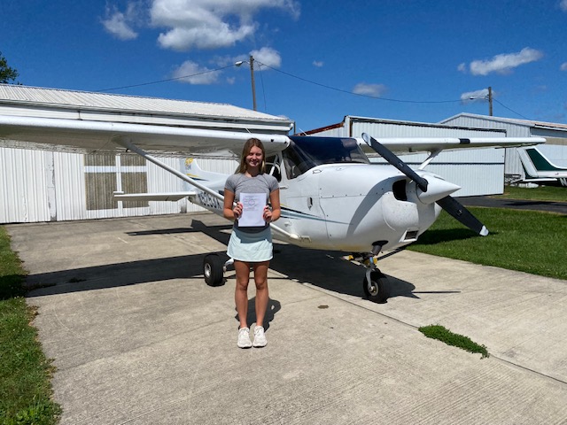 Student pilot celebrating checkride success with flight instructor at Eagle Aircraft